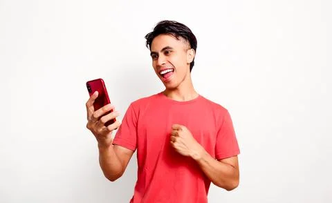 Excited young asian man using and looking at smartphone showing celebrate s.. Stock Photos