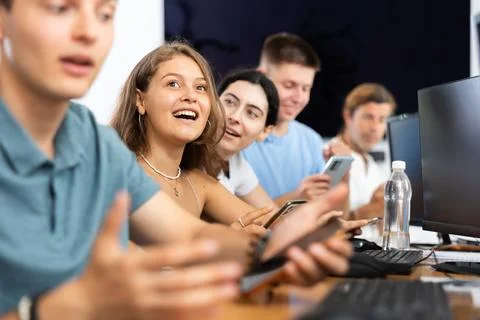 Excited young female developer using mobile phone at IT startup presentation Foto stock
