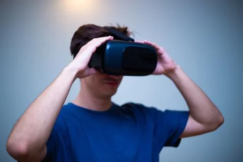 An excited young guy in virtual reality glasses is immersed in the metaverse Stock Photos