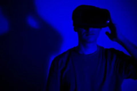 An excited young guy in virtual reality glasses is immersed in the metaverse Stock Photos