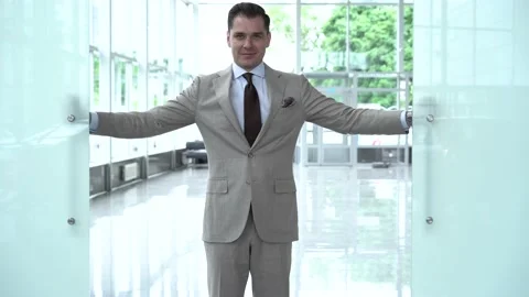 Excited young man opens the door to the modern office Stock Footage 134461259