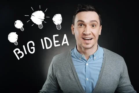 Excited young man smiling while getting a brilliant idea 库存照片