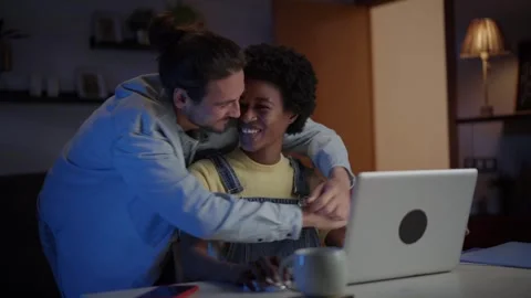 Excited young multiracial couple affectionate looking sales together on computer Stock Footage 253860587