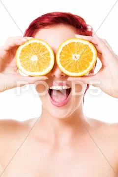 Excited young woman holding oranges over her eyes Stock Photos