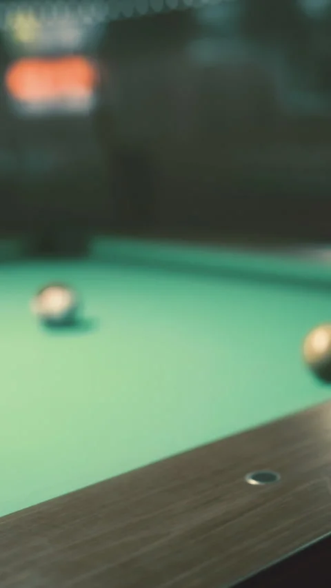 Excitement builds around the green pool table in a lively game room setting Video stock 331367633