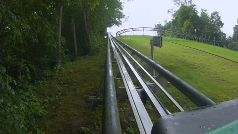 Exciting mountain coaster ride through lush greenery at local amusement park Video stock 314424338