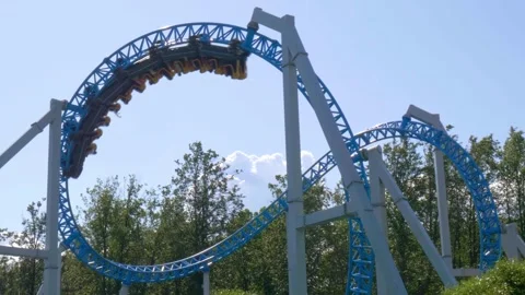 Exciting Roller Coaster Twists and Turns at Amusement Park on a Sunny Day in Stock Footage 312566226