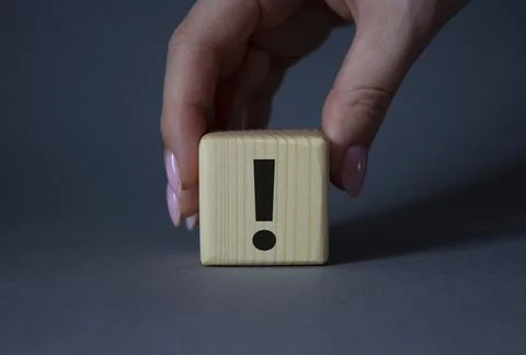 Exclamation mark symbol. Exclamation mark on wooden cubes. Businessman hand.. Stock Photos
