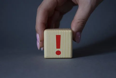 Exclamation mark symbol. Exclamation mark on wooden cubes. Businessman hand.. Stock Photos