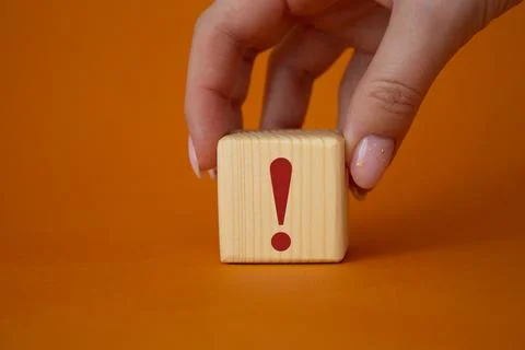 Exclamation mark symbol. Exclamation mark on wooden cubes. Businessman hand.. Stock Photos