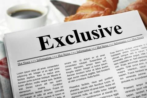 Exclusive newspaper layout on a breakfast table with a blurry cup of coffee.. Stock Photos