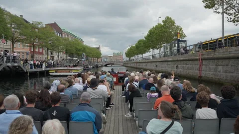 Excursion boat carries passengers along Slotsholmskanalen by Gammel Strand Stock Footage 345495245