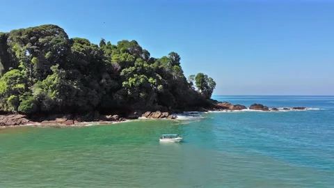 Excursion boat exploring beautiful tropical paradise cove on turquoise water Stock Footage 154333626