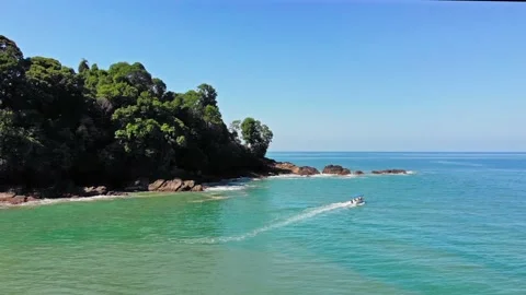 Excursion boat exploring beautiful tropical paradise cove on turquoise water Stock Footage 154333908