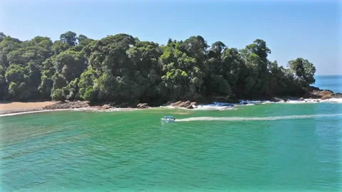 Excursion boat exploring beautiful tropical paradise cove on turquoise water Video stock 154333945