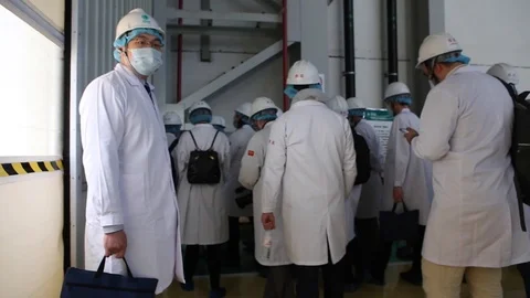An excursion, people in White robes go through the factory workshop,transformers Stock Footage 88336635