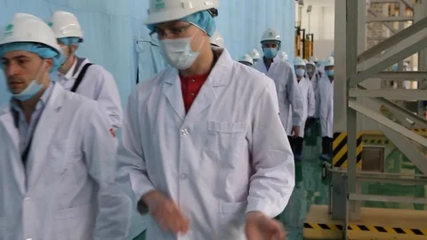 An excursion, people in White robes go through the factory workshop,transformers Stock Footage 88336653
