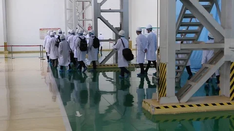 An excursion, people in White robes go through the factory workshop,transformers Stock Footage 88336655