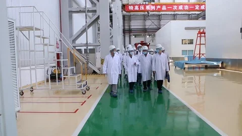An excursion, people in White robes go through the factory workshop,transformers Stock Footage 88336675