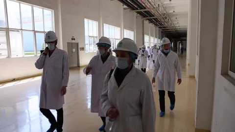 An excursion, people in White robes go through the factory workshop,transformers Stock Footage 88336677