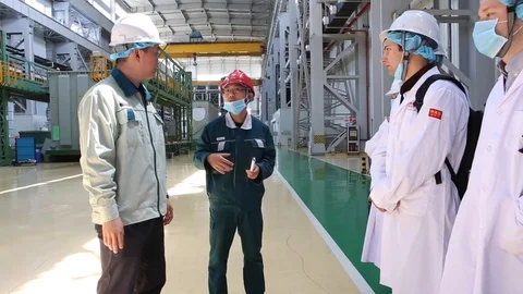 An excursion, people in White robes go through the factory workshop,transformers Stock Footage 88336696
