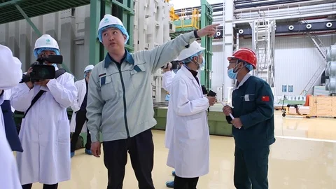 An excursion, people in White robes go through the factory workshop,transformers Stock Footage 88336722