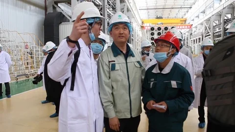 An excursion, people in White robes go through the factory workshop,transformers Stock Footage 88336732