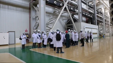 An excursion, people in White robes go through the factory workshop,transformers Stock Footage 88336752