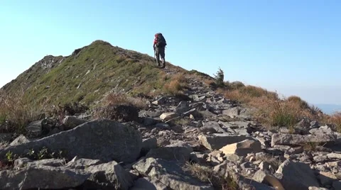 Excursionist who climbs on an upward path on mountainside 22c Stock Footage 58120761