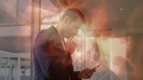 Exec by glass wall glancing at phone and tapping checking mail, warm effect Stock Footage 331175994