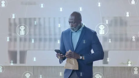 Exec opening bag in atrium, scrolling phone, network icons floating around him, Stock Footage 333540240