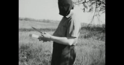 Executioner in a mask with an ax and a knife in his hand is training to throw a Stock Footage 263150891