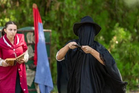 Executioner sharpening knife getting ready to behead historian woman 库存照片