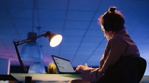 Executive assistant listening to music late at night Stock Footage 233848174