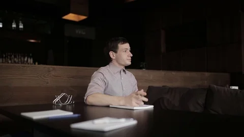 Executive businesman writing his idea at notebook, sitting at cafe indoors. Stock Footage 69886888