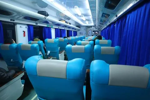 Executive class train interior with blue seats, armrests, luggage racks, mo.. Stock Photos