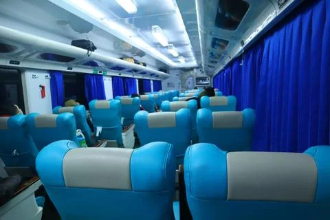 Executive class train interior with blue seats, armrests, luggage racks, mo.. Stock Photos