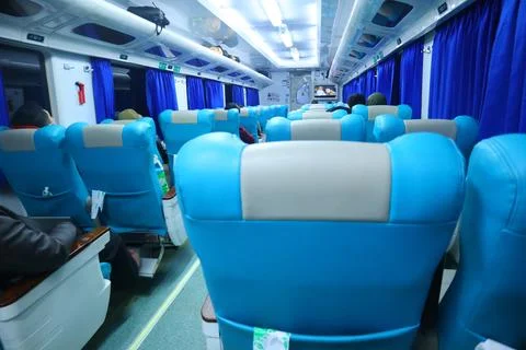 Executive class train interior with blue seats, armrests, luggage racks, mo.. Stock Photos