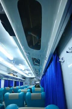 Executive class train interior with blue seats, armrests, luggage racks, mo.. Stock Photos