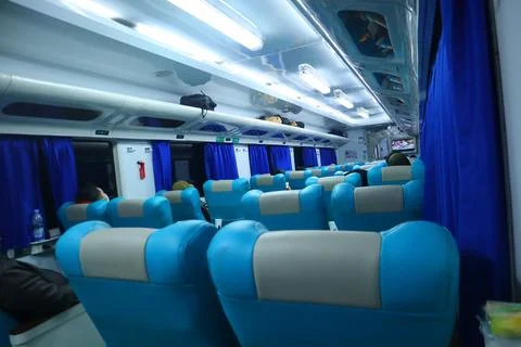 Executive class train interior with blue seats, armrests, luggage racks, mo.. Stock Photos