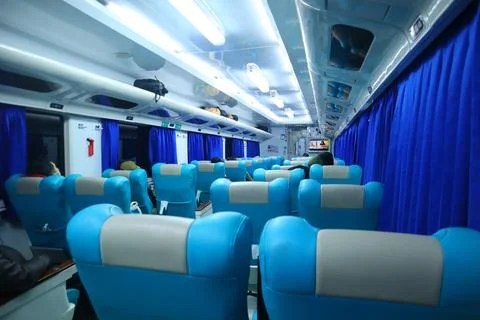 Executive class train interior with blue seats, armrests, luggage racks, mo.. Stock Photos