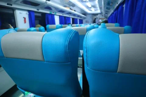 Executive class train interior with blue seats, armrests, luggage racks, mo.. Stock Photos