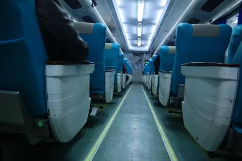 Executive class train interior with blue seats, armrests, luggage racks, mo.. Stock Photos
