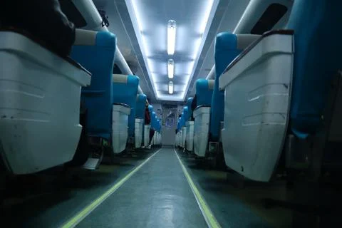 Executive class train interior with blue seats, armrests, luggage racks, mo.. Stock Photos