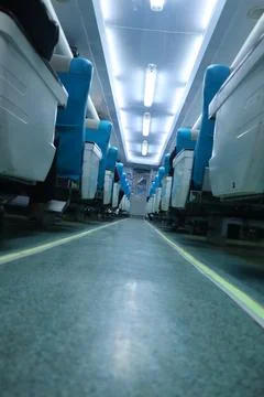 Executive class train interior with blue seats, armrests, luggage racks, mo.. Stock Photos
