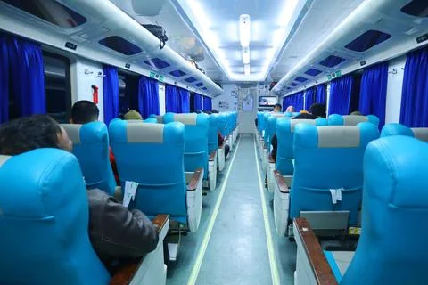 Executive class train interior with blue seats, armrests, luggage racks, mo.. Stock Photos