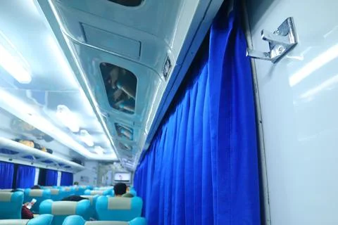 Executive class train interior with blue seats, armrests, luggage racks, mo.. Stock Photos