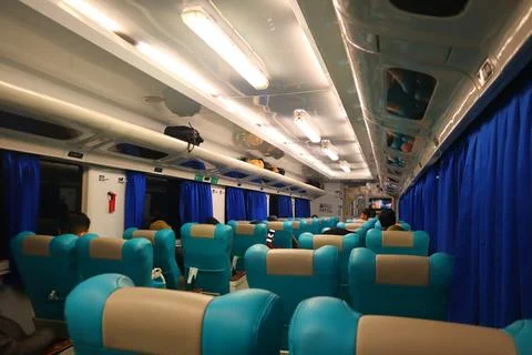 Executive class train interior with blue seats, armrests, luggage racks, mo.. Stock Photos