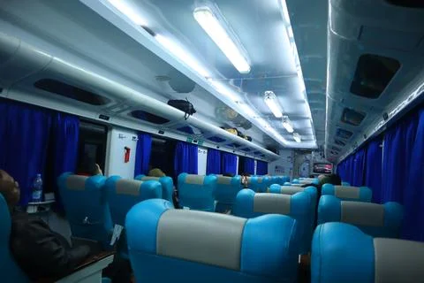 Executive class train interior with blue seats, armrests, luggage racks, mo.. Stock Photos