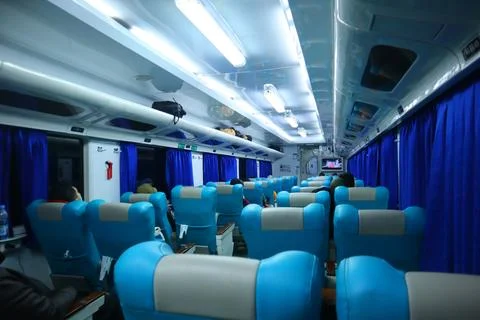 Executive class train interior with blue seats, armrests, luggage racks, mo.. Stock Photos
